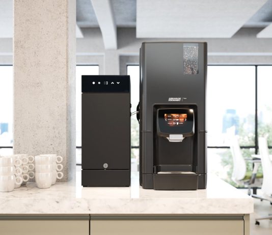 Gamme expresso Bravilor : trois machines, une même exigence à la tasse Gamme expresso Bravilor : la Sego et son réfrigérateur à lait frais sur un comptoir de bureau